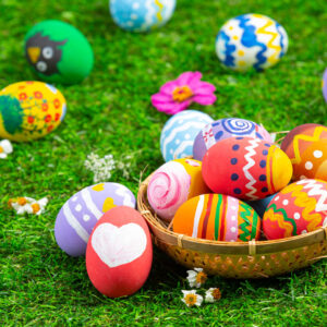 colorful easter eggs on the grass and in a brown basket