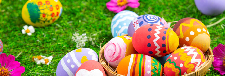 colorful easter eggs on the grass and in a brown basket