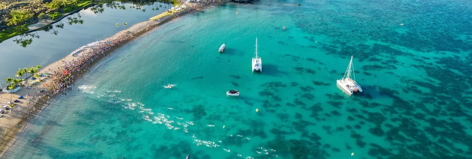 people on the beach of A bay waiting for the swim race to start for the Lavaman Triathlon